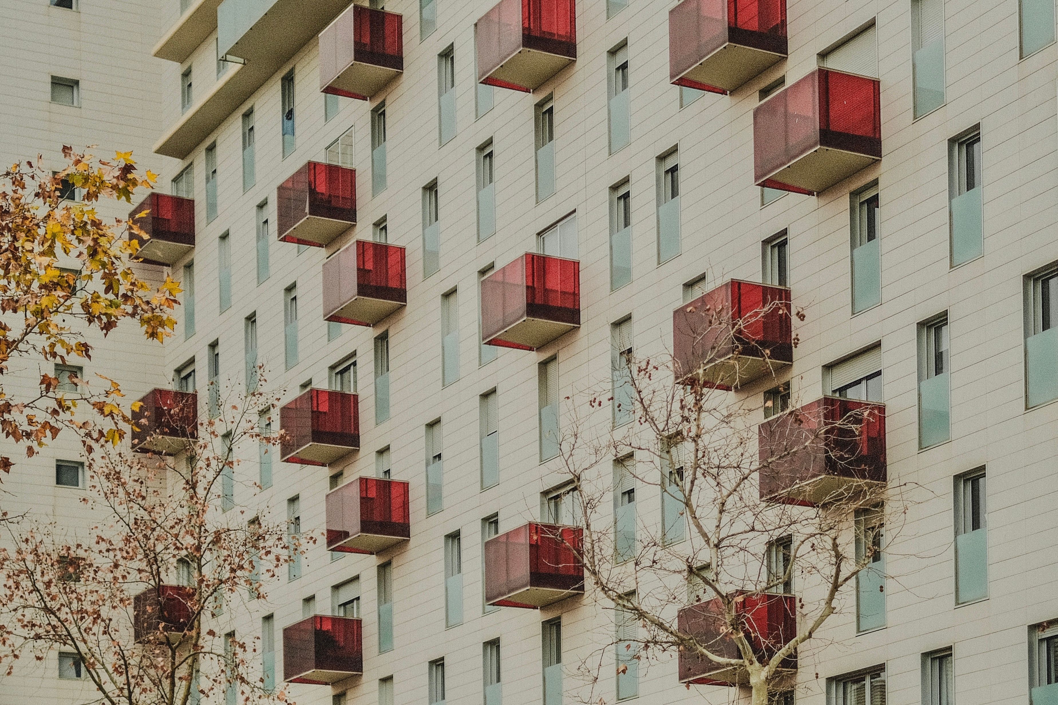 Modern Apartment Building with Red Balconies · Free Stock Photo