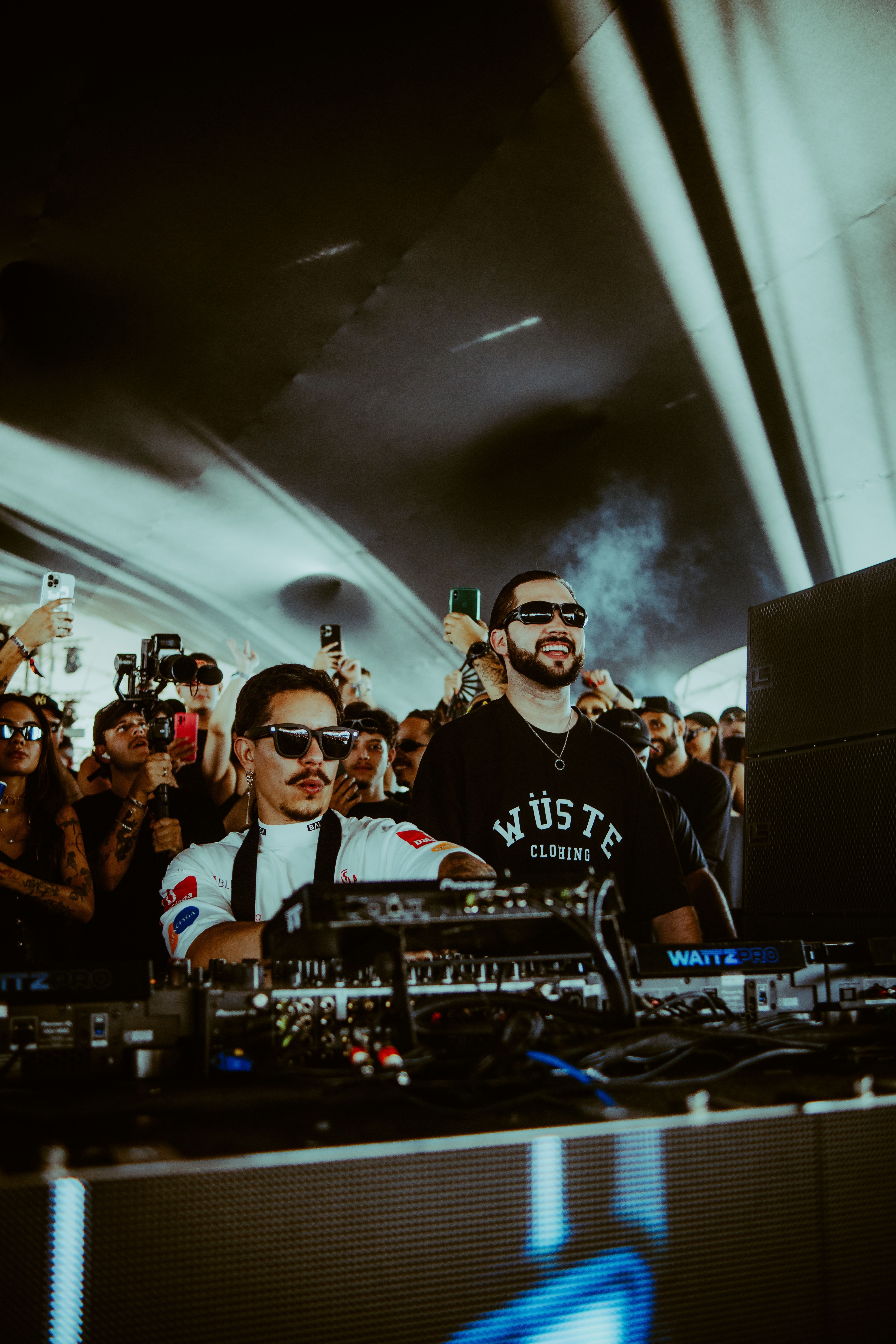DJs performing live at a packed music festival with enthusiastic crowd.