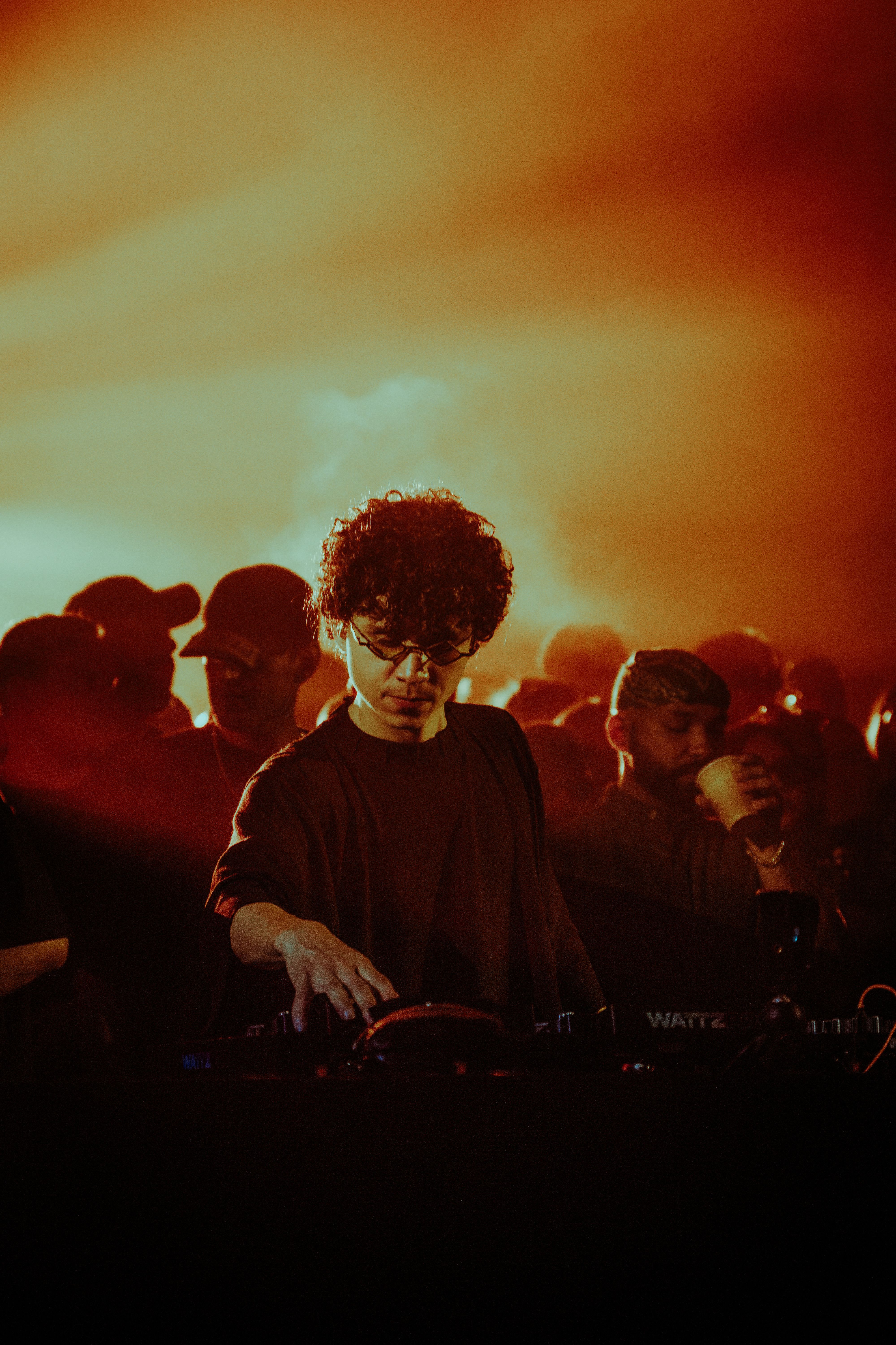 DJ electrifies a lively crowd with dynamic beats at an energetic nightclub event.