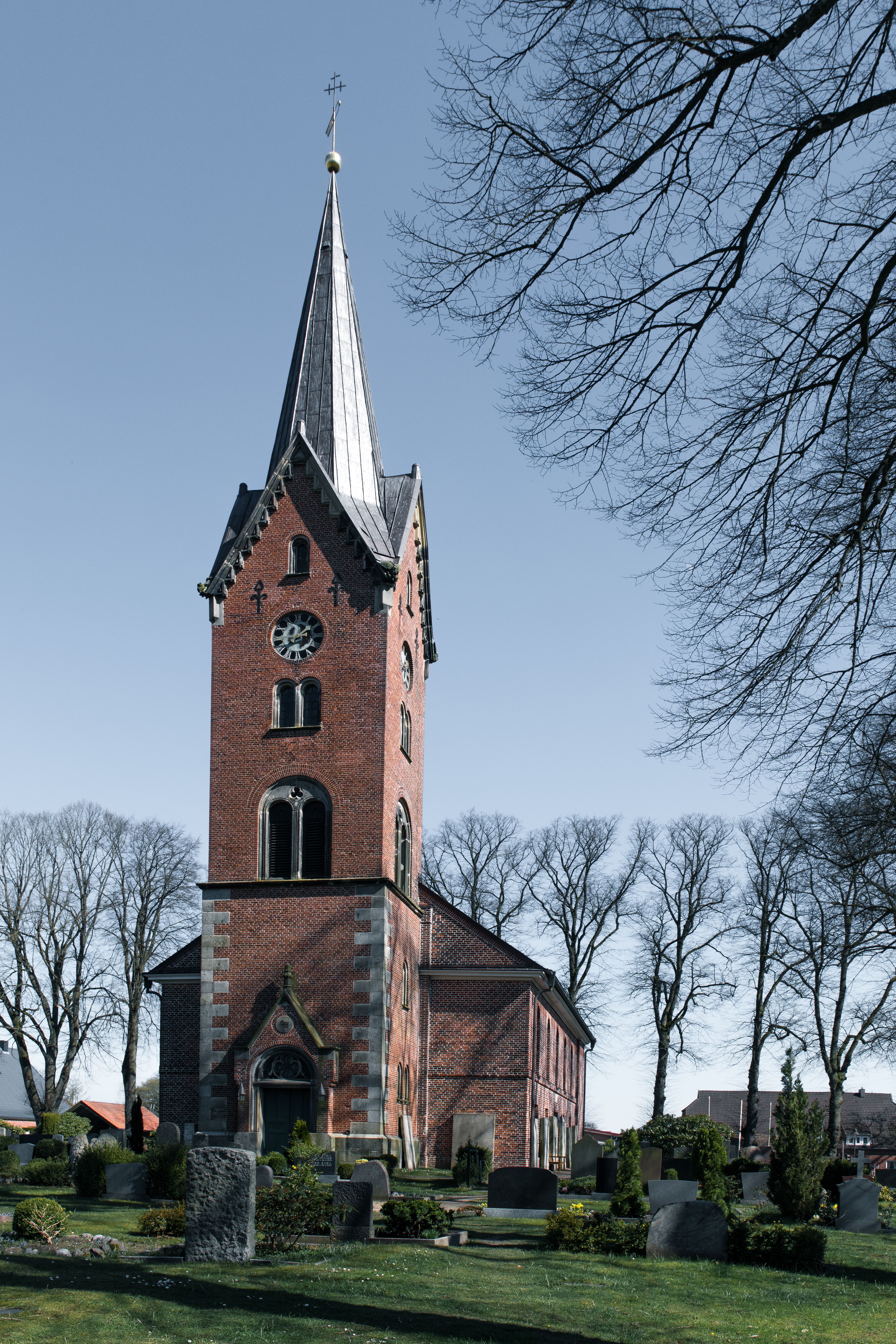 Scenic view of a historic church tower in Hohenhorn, Germany, surrounded by trees.