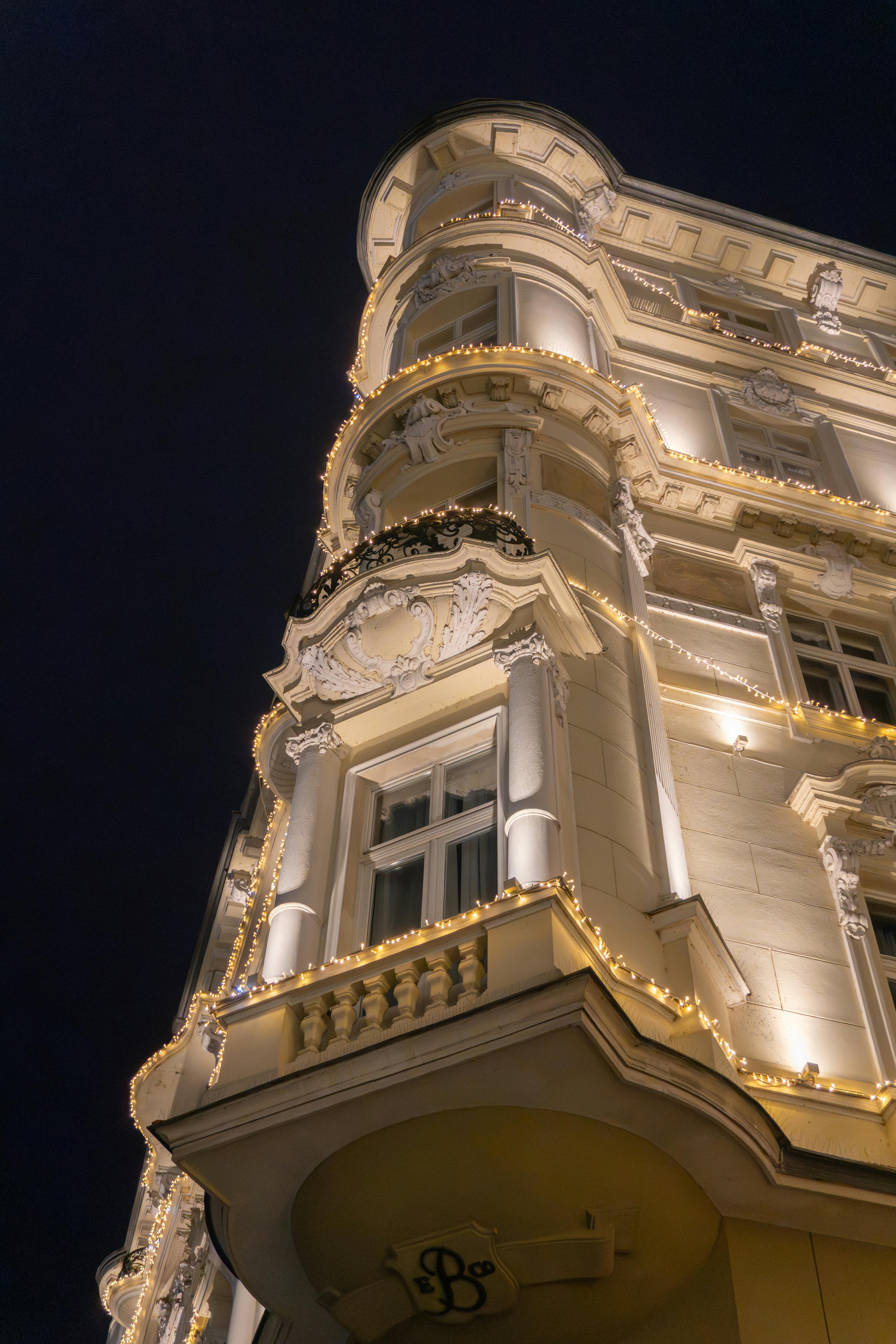 Ücretsiz Yılbaşı ışıklarıyla muhteşem bir şekilde aydınlatılmış, süslü bir Avrupa binasının cephesinin gece görünümü. Stok Fotoğraflar