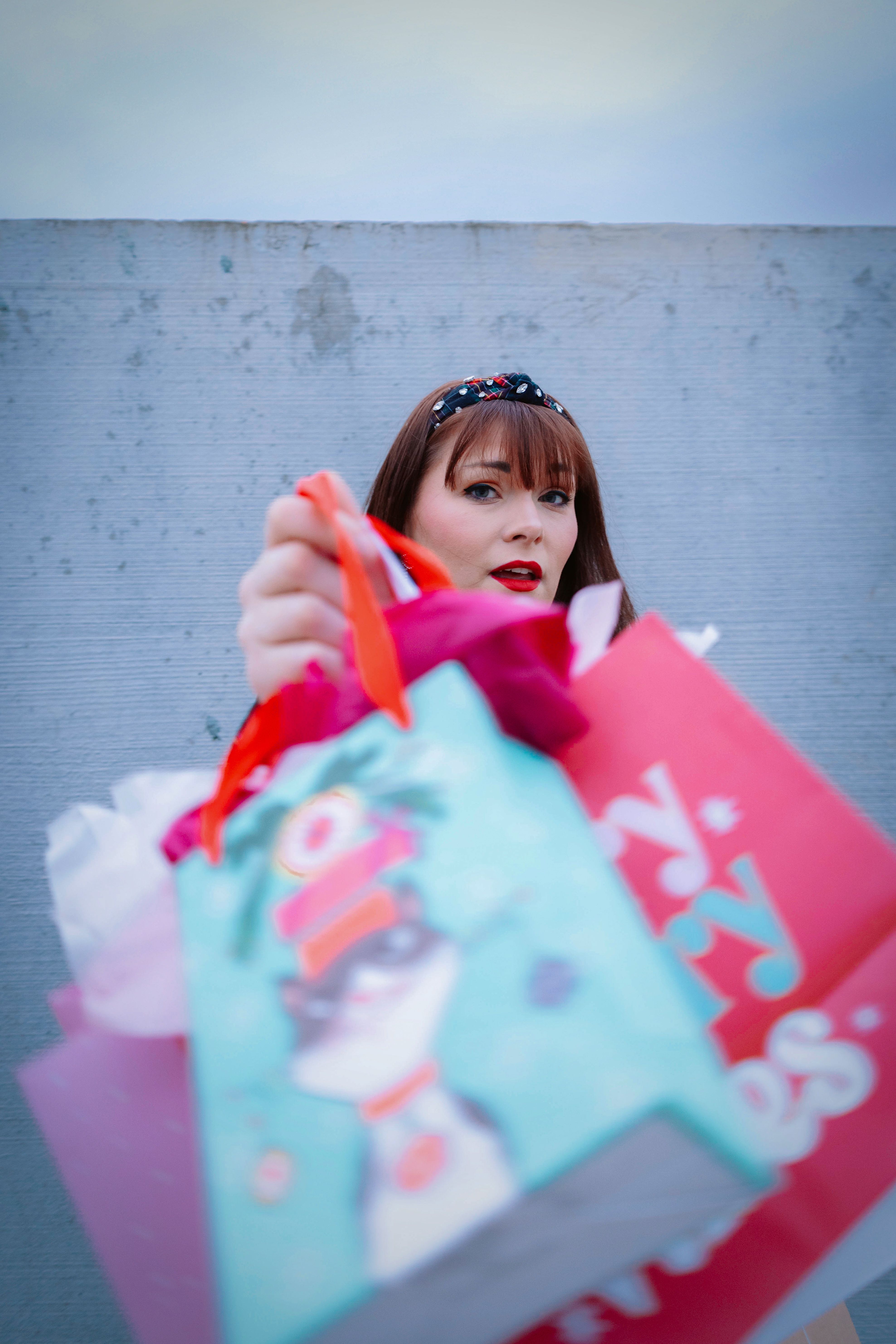A woman holding colorful shopping bags during holiday season in Broomfield, Colorado, USA.