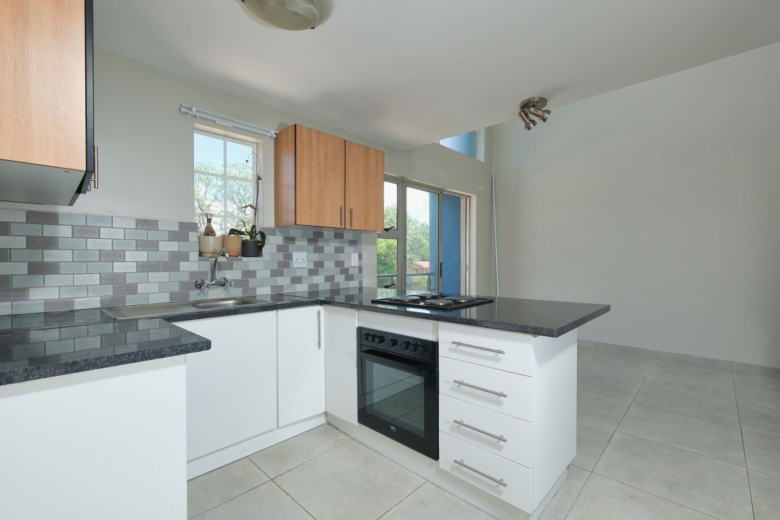 Modern tiled kitchen interior with bright floor tiles and tiled backsplash