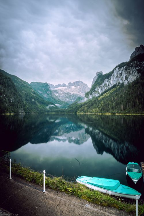 Free Tranquil alpine lake in Gosau, Austria, reflecting mountains under a cloudy sky. Stock Photo