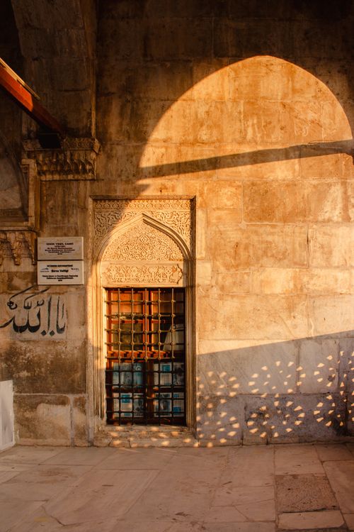 Free Sunlit facade of a historic building with ornate archway and rich textures. Stock Photo