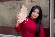 Woman in Traditional Vietnamese Attire with Fan