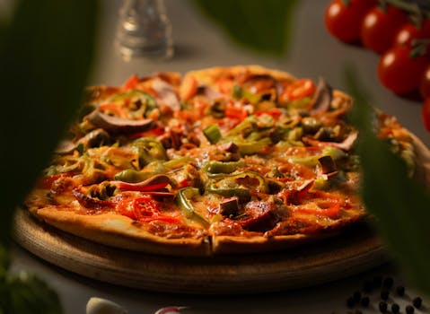 Close-up image of a vegetarian pizza topped with bell peppers, onions, and mushrooms.