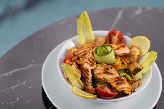 Delicious grilled chicken Caesar salad with fresh vegetables served on a marble table.