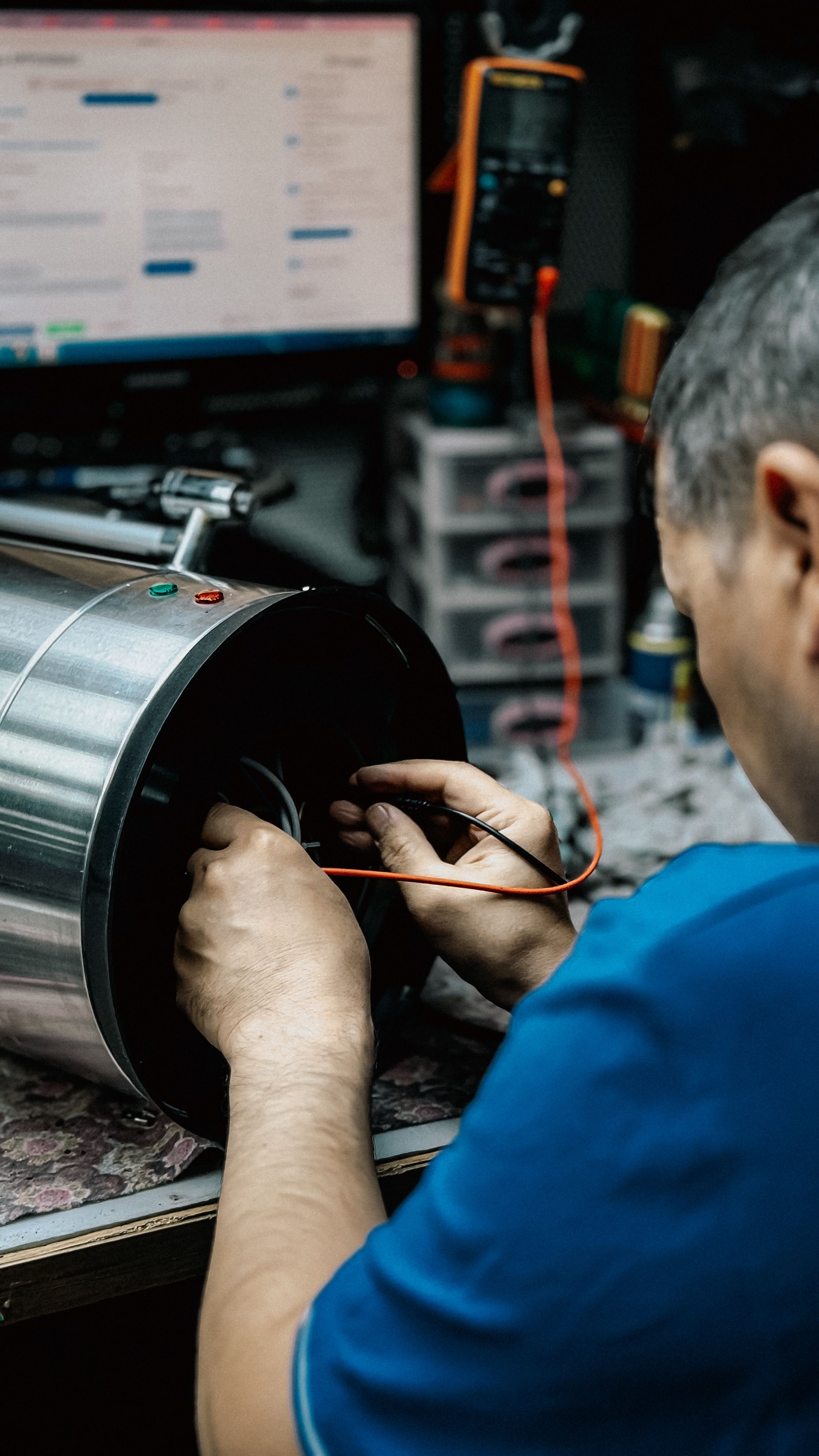Technicien examinant et réparant un équipement mécanique industriel dans un atelier