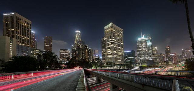 Vibrant long exposure of Downtown Los Angeles skyscrapers at night, showcasing the city skyline.