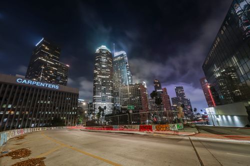 Free Vibrant night view of downtown Los Angeles with illuminated skyscrapers and light trails. Stock Photo