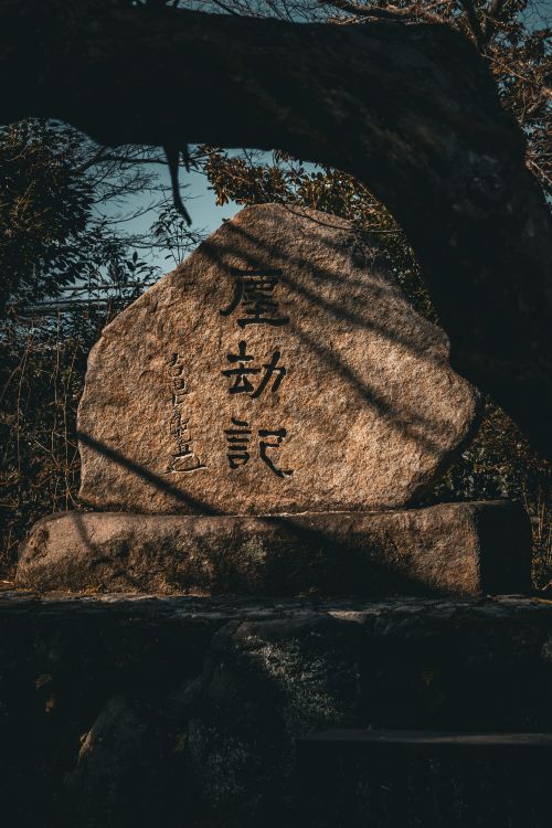 Free Stone inscription with Japanese characters in Kyoto's serene outdoor setting. Stock Photo