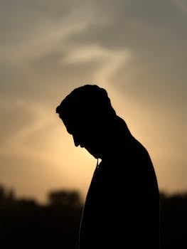 A solitary silhouette of a person at sunset evokes contemplation and solitude.