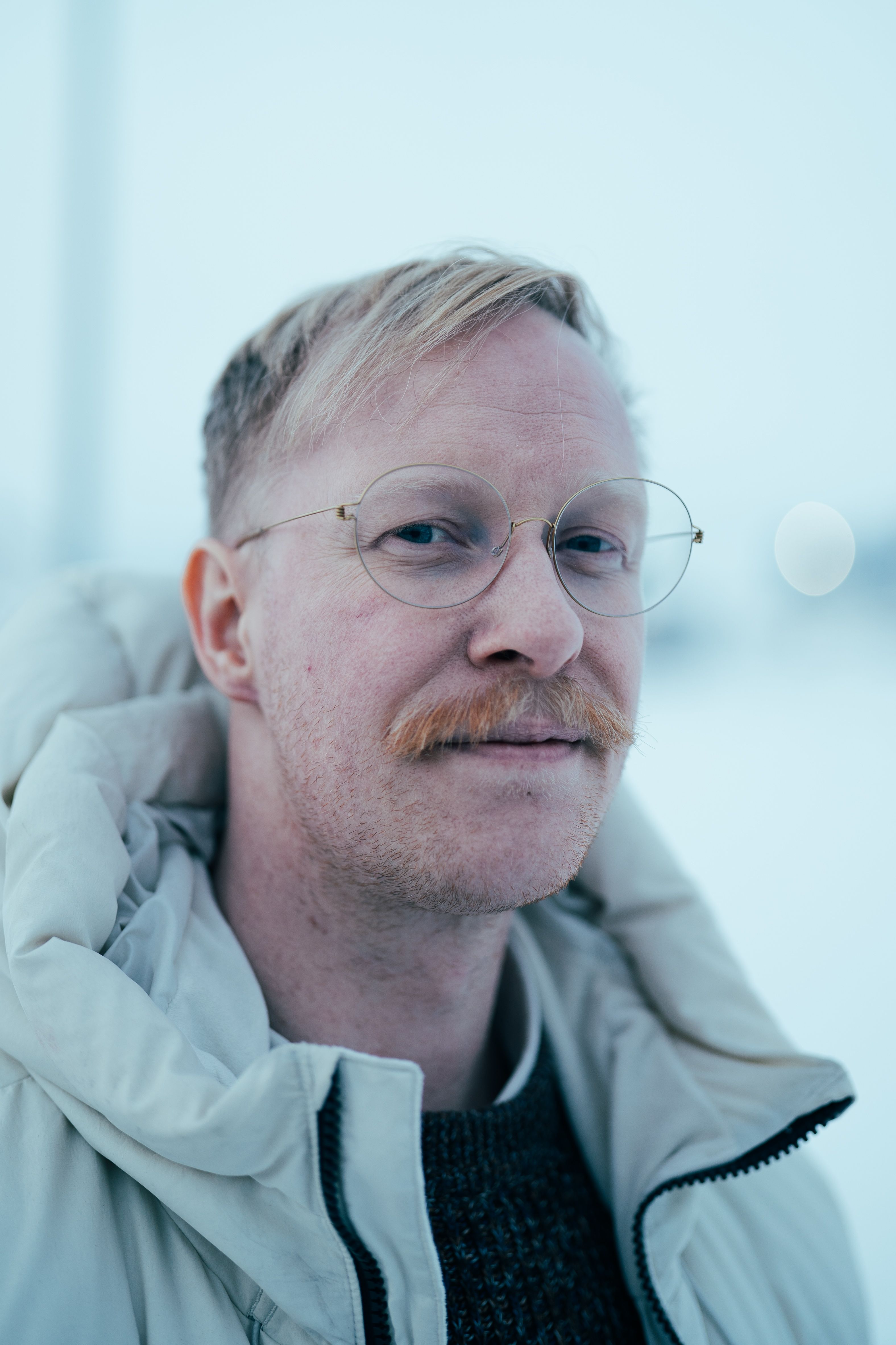 Close-up of a smiling man in winter attire, outdoors in Nuuk, Greenland.