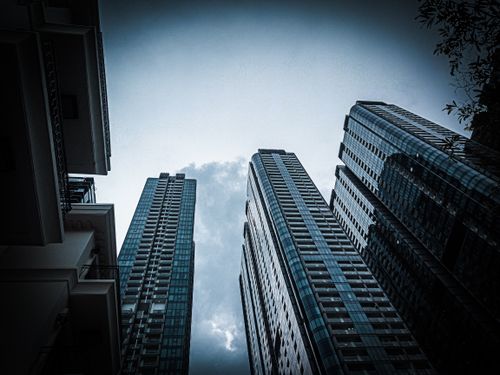 Free Imposing skyscrapers rise dramatically against a moody blue sky, capturing modern urban life. Stock Photo