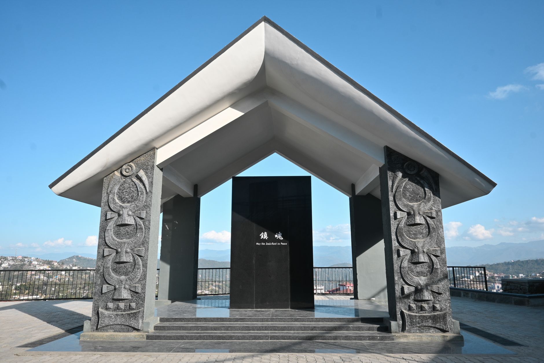 A striking architectural war memorial in Kohima, Nagaland, standing prominently under clear blue skies.