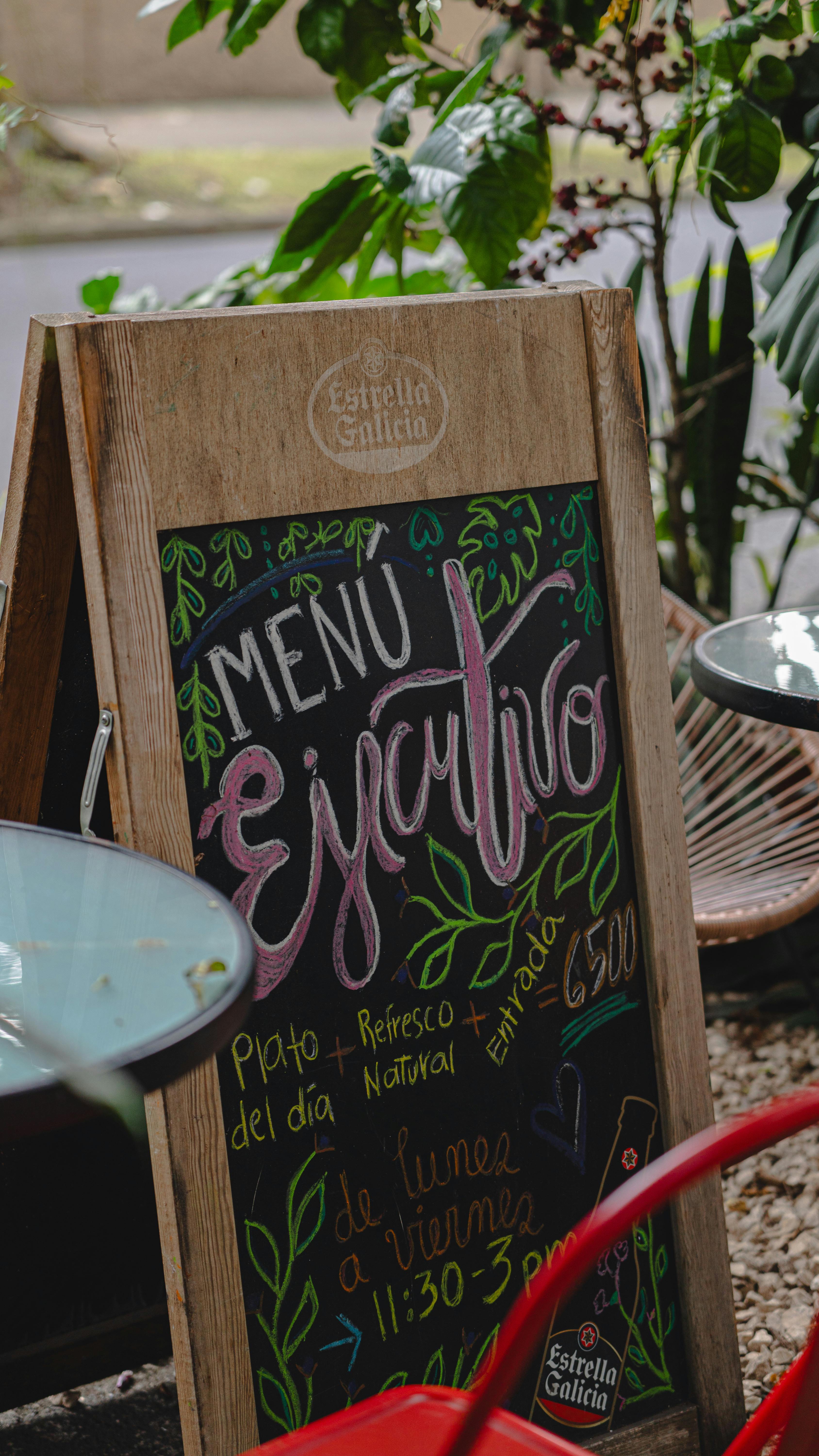 Chalkboard sign displaying menu details at an outdoor café.
