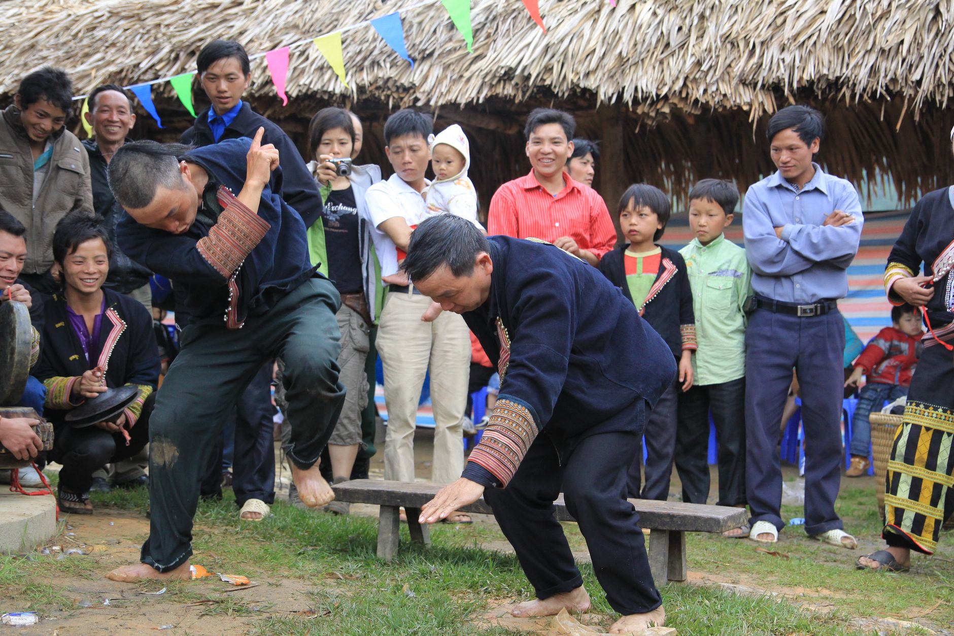 Men performing a traditional dance surrounded by a crowd at a cultural festival.