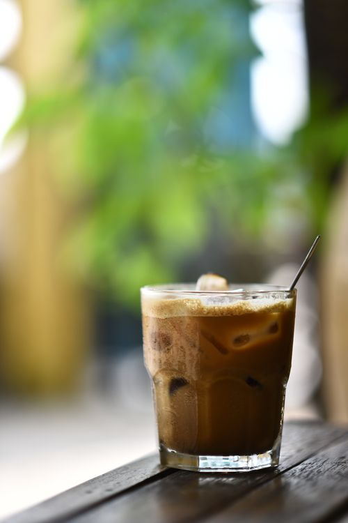 Free Refreshing glass of iced coffee with a straw, perfect for a sunny day outdoors. Stock Photo