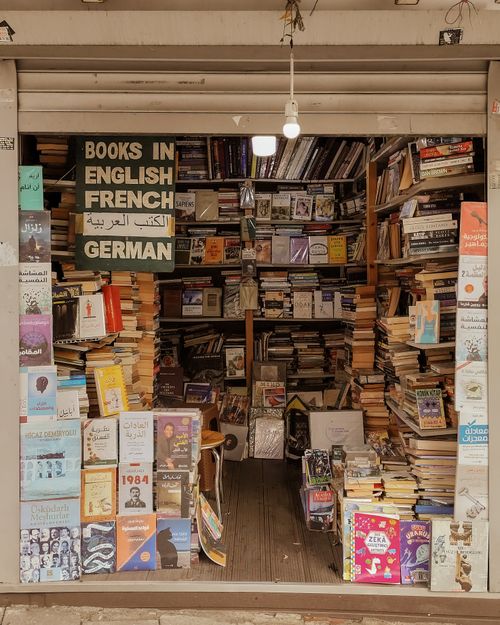 Free A small bookstore packed with books in English, French, German, and Arabic, creating a cozy literary haven. Stock Photo