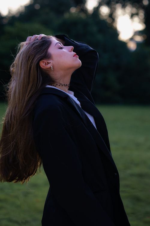Free Young woman in black suit posing in a Berlin park during sunset. Stock Photo