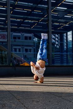 Talented dancer showcasing a headstand on city street, Berlin, Germany.
