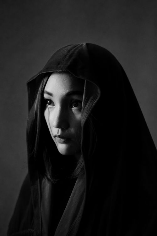Free Artistic black and white portrait capturing a woman in a hooded cloak. Stock Photo