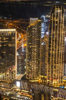 A stunning aerial view of Dubai's illuminated skyscrapers towering over the night-lit cityscape.