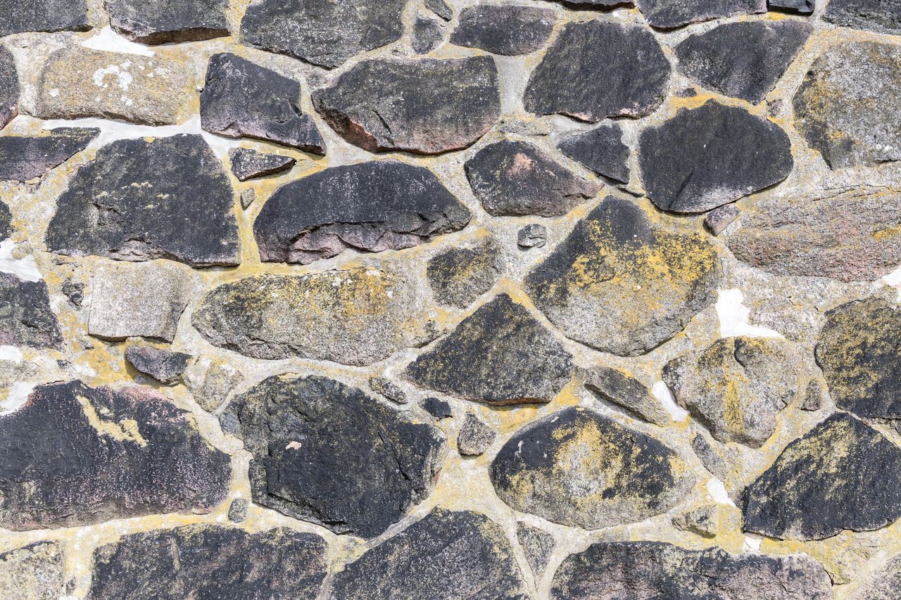 close up of an ancient stone masonry wall showcasing natural rock text