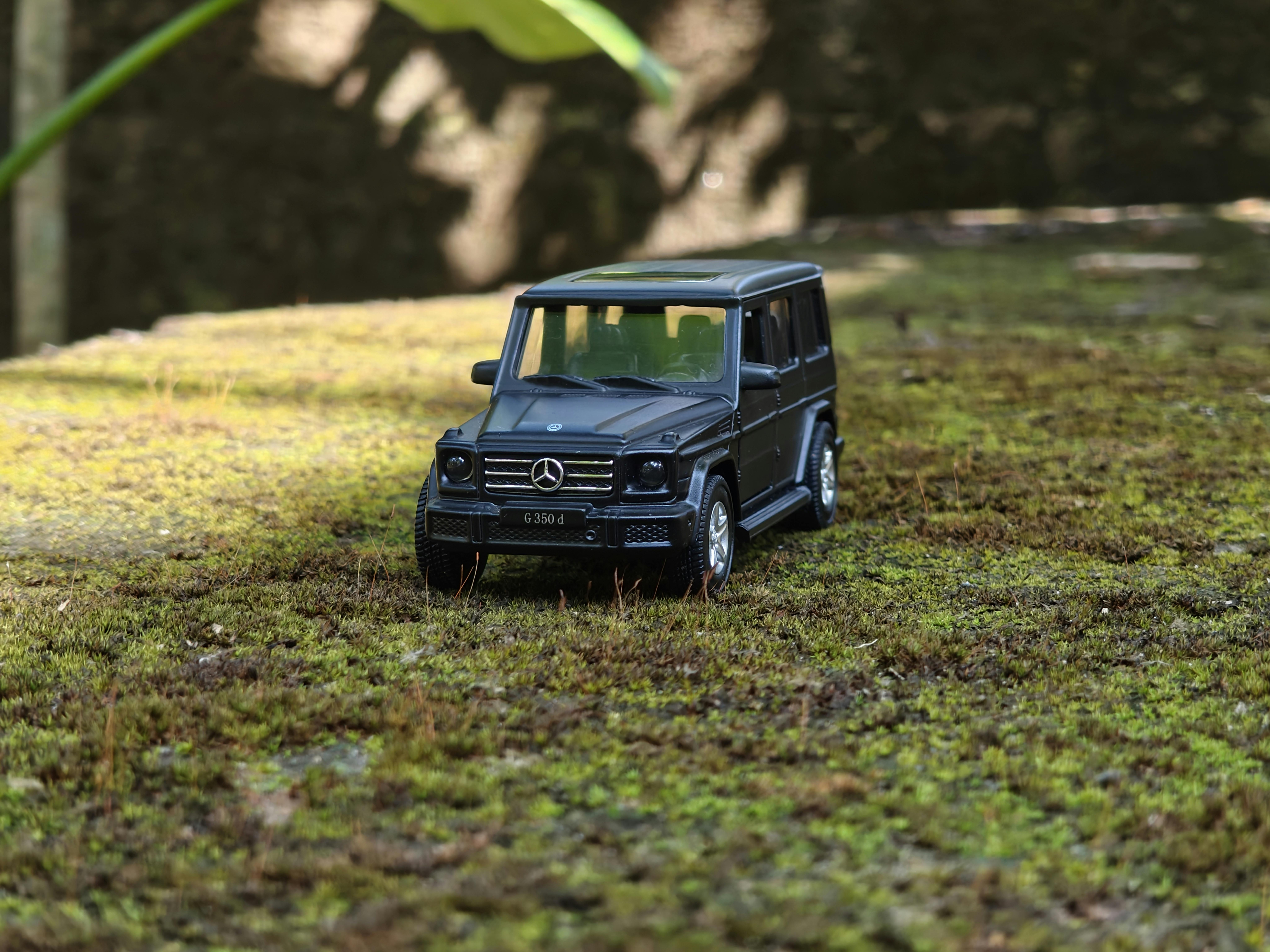 Gratis Miniature sort SUV-model parkeret på grøn mos, der fremviser udendørs bilfotografering. Lagerfoto
