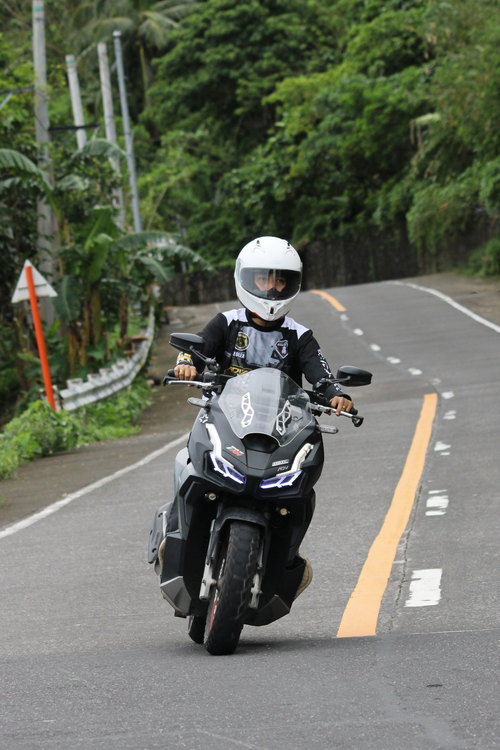 Free Motorcyclist navigating a road in Sagnay, Bicol, Philippines with lush greenery around. Stock Photo