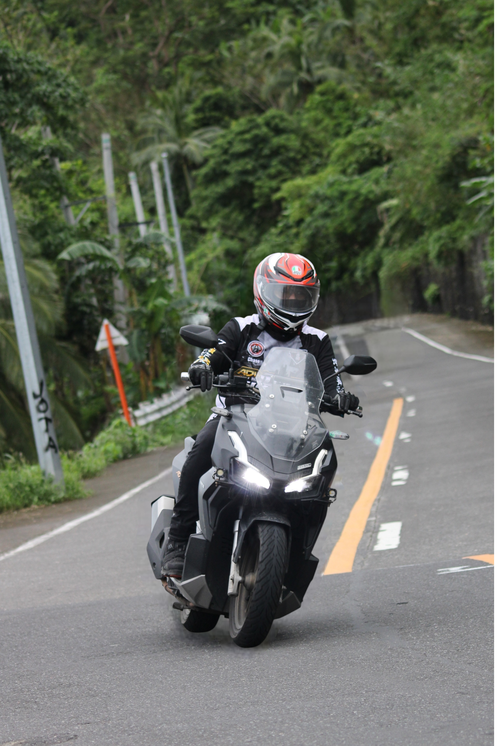 Motorcyclist maneuvering curve on forest road, showcasing adventure and freedom.