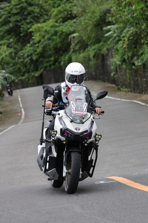 Free A motorcyclist wearing gear cruises along a winding mountain road. Stock Photo
