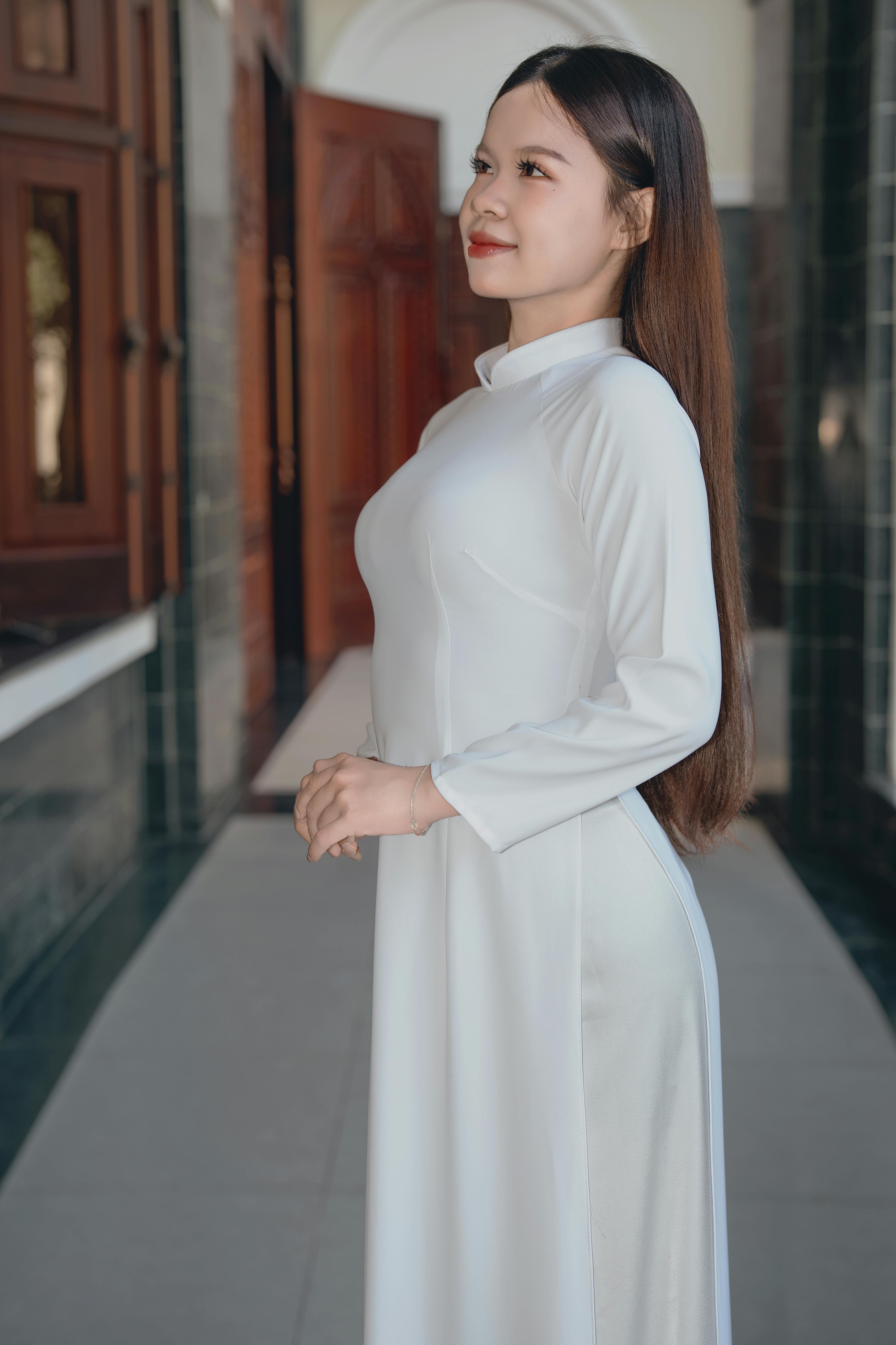 Portrait of an elegant woman in a traditional white dress indoors.