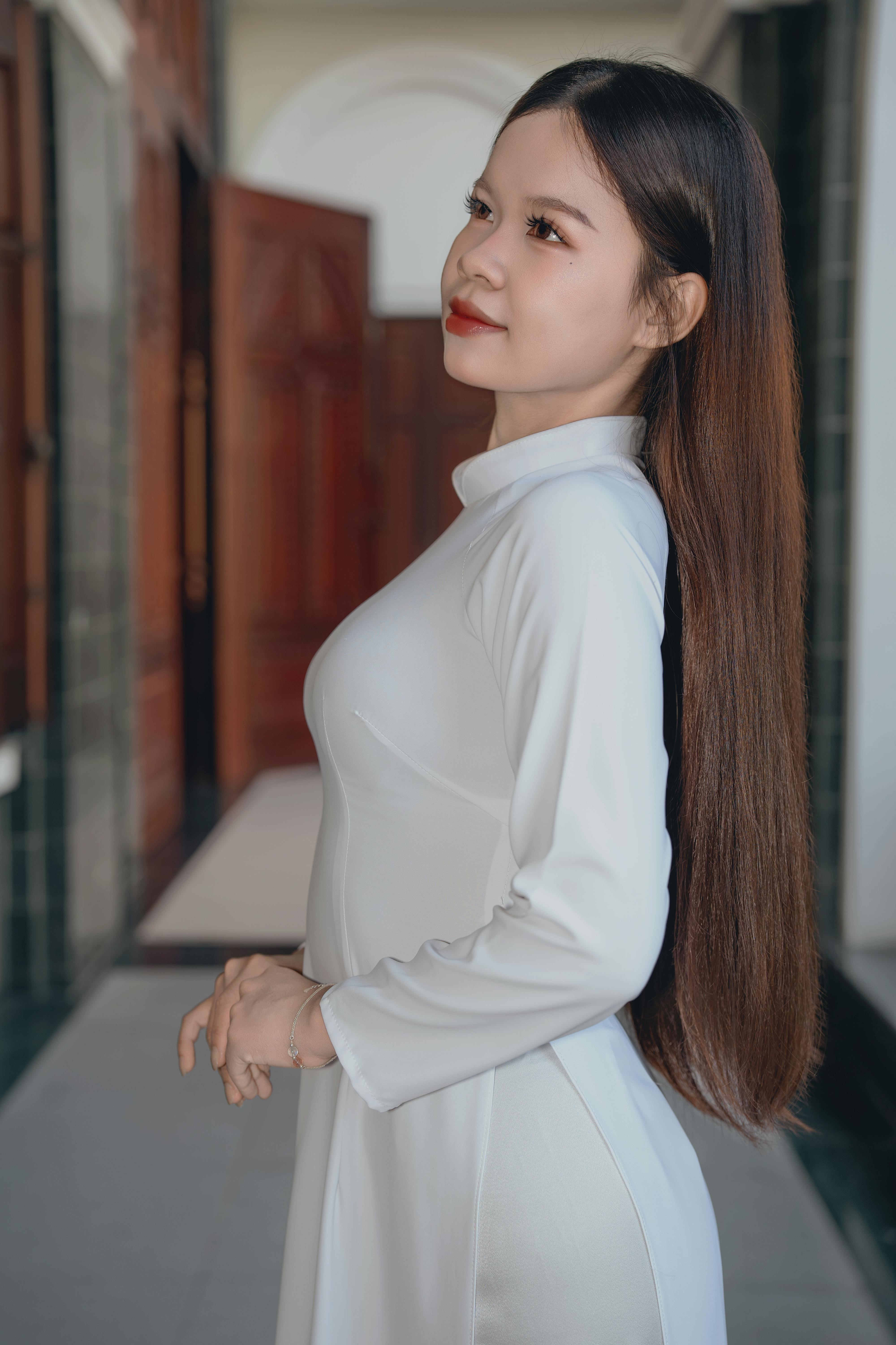 Stunning portrait of a woman in white traditional attire with long hair, indoors.