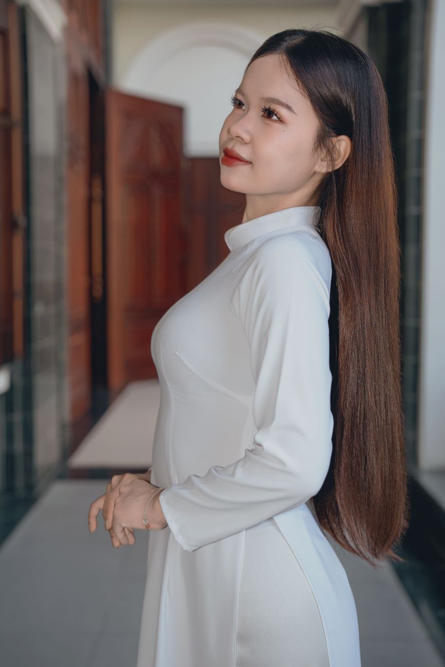Stunning portrait of a woman in white traditional attire with long hair, indoors.