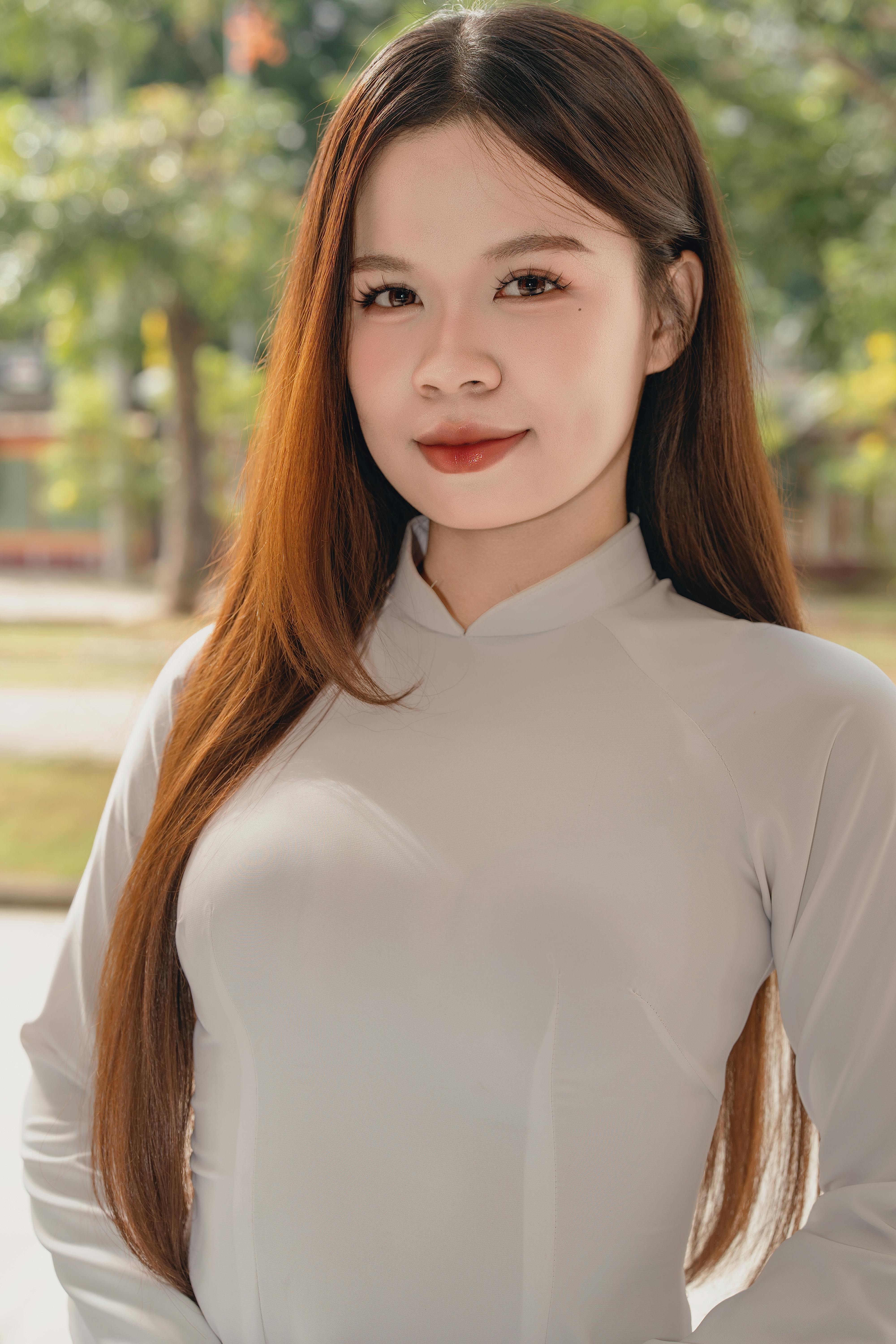 Beautiful young woman in traditional outfit posing outdoors on a sunny day.