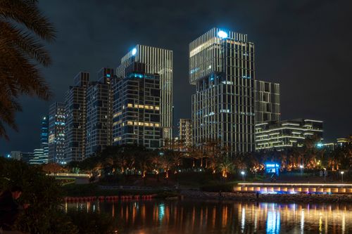 Free City skyline at night with illuminated skyscrapers reflecting in water. Stock Photo