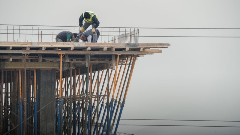 Workers on a high-rise building construction site in Denizli, Türkiye, showcasing teamwork and safety.
