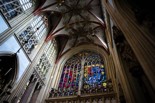 Stunning view of a Gothic cathedral ceiling and vivid stained glass windows.