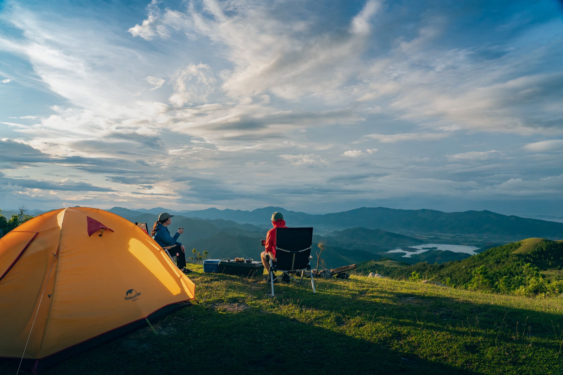 Two people enjoy a serene sunrise camping in the mountains of Quảng Ninh, Vietnam.