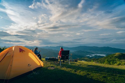Free Two people enjoy a serene sunrise camping in the mountains of Quảng Ninh, Vietnam. Stock Photo