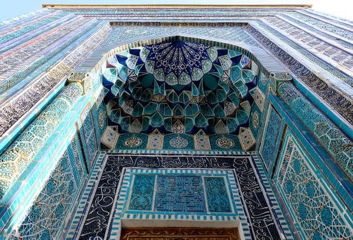 Close-up of intricate blue and turquoise Islamic tiles on a building facade.