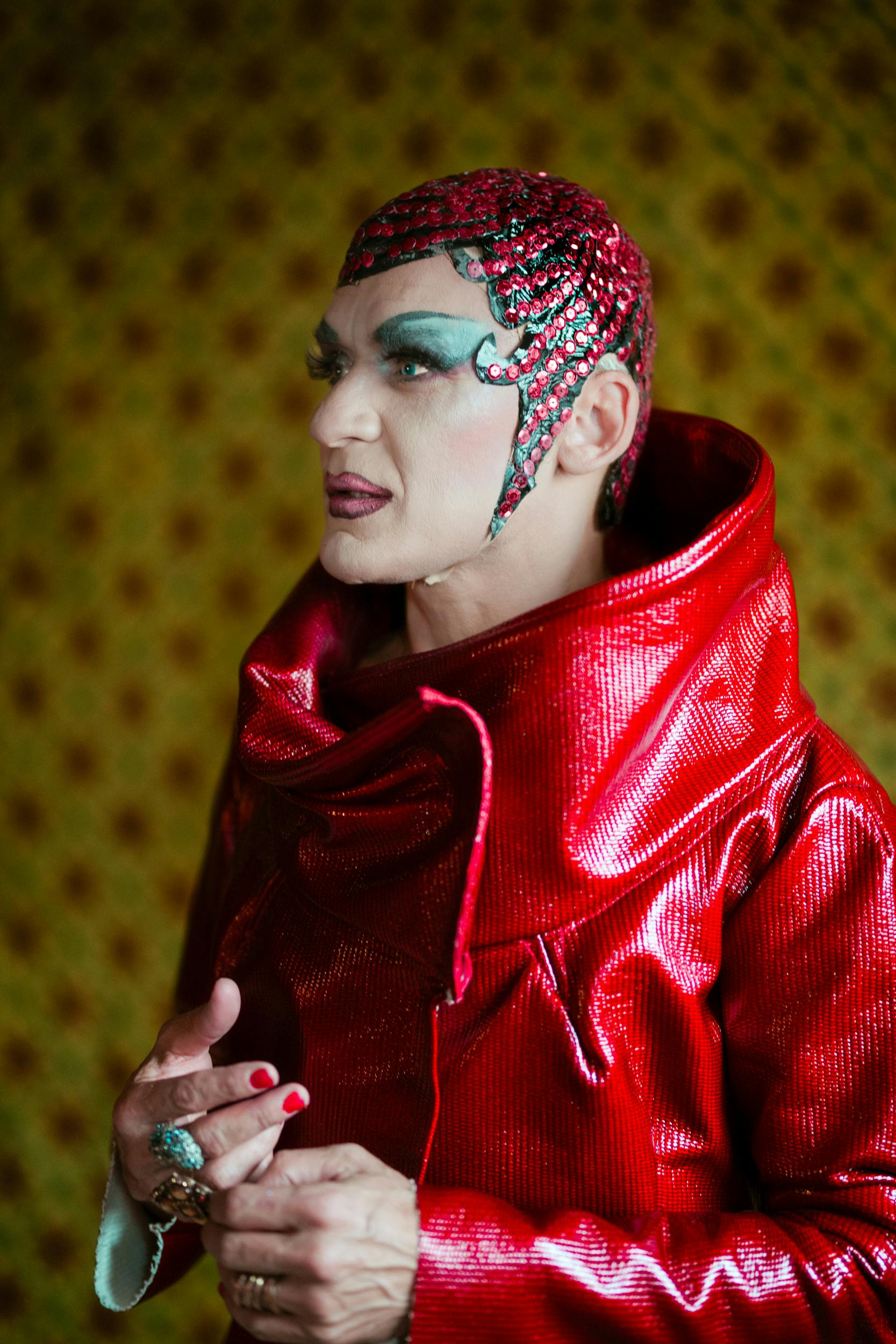 Free Artistic performer in red costume with elaborate makeup and background. Stock Photo