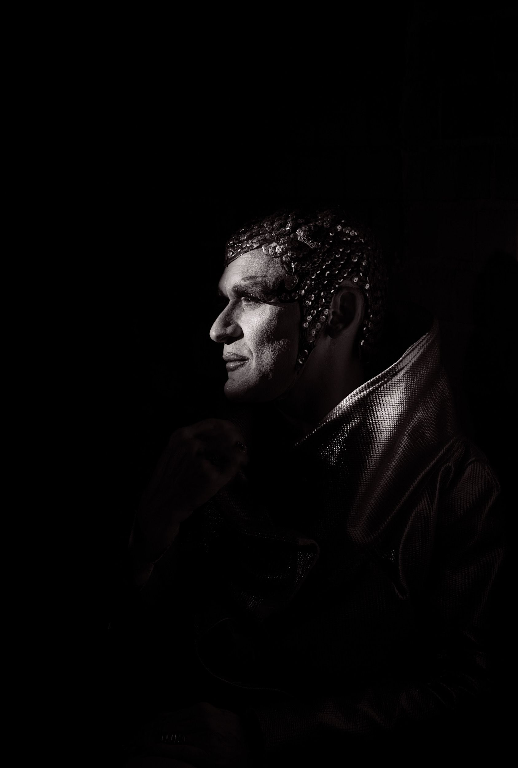 Artistic black and white portrait of a man with dramatic lighting and unique styling.