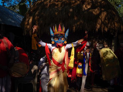 Free A vibrant scene of traditional Indian dancers wearing colorful masks performing outdoors. Stock Photo
