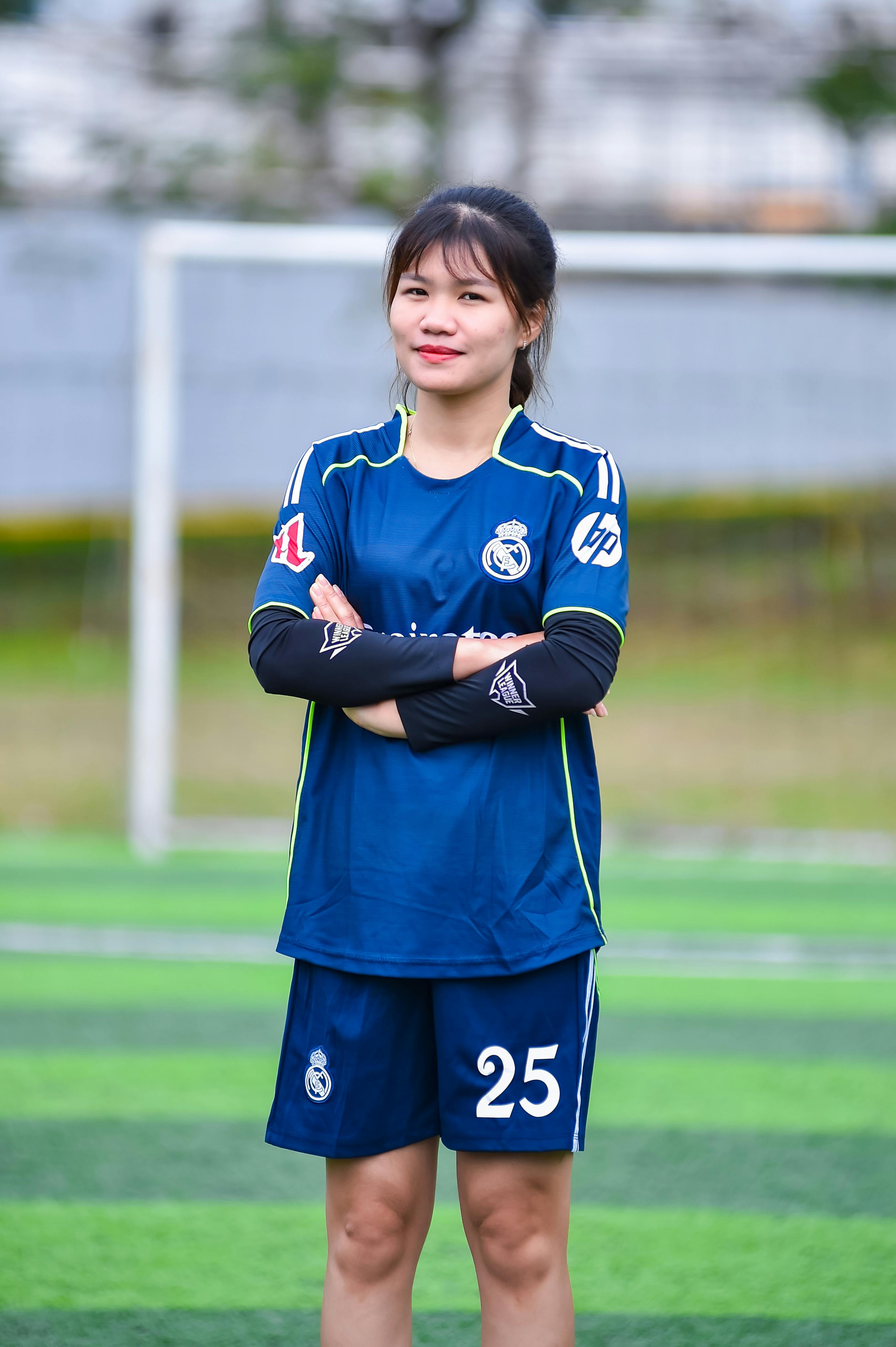 Young female soccer player posing confidently on a field in Hà Nội.