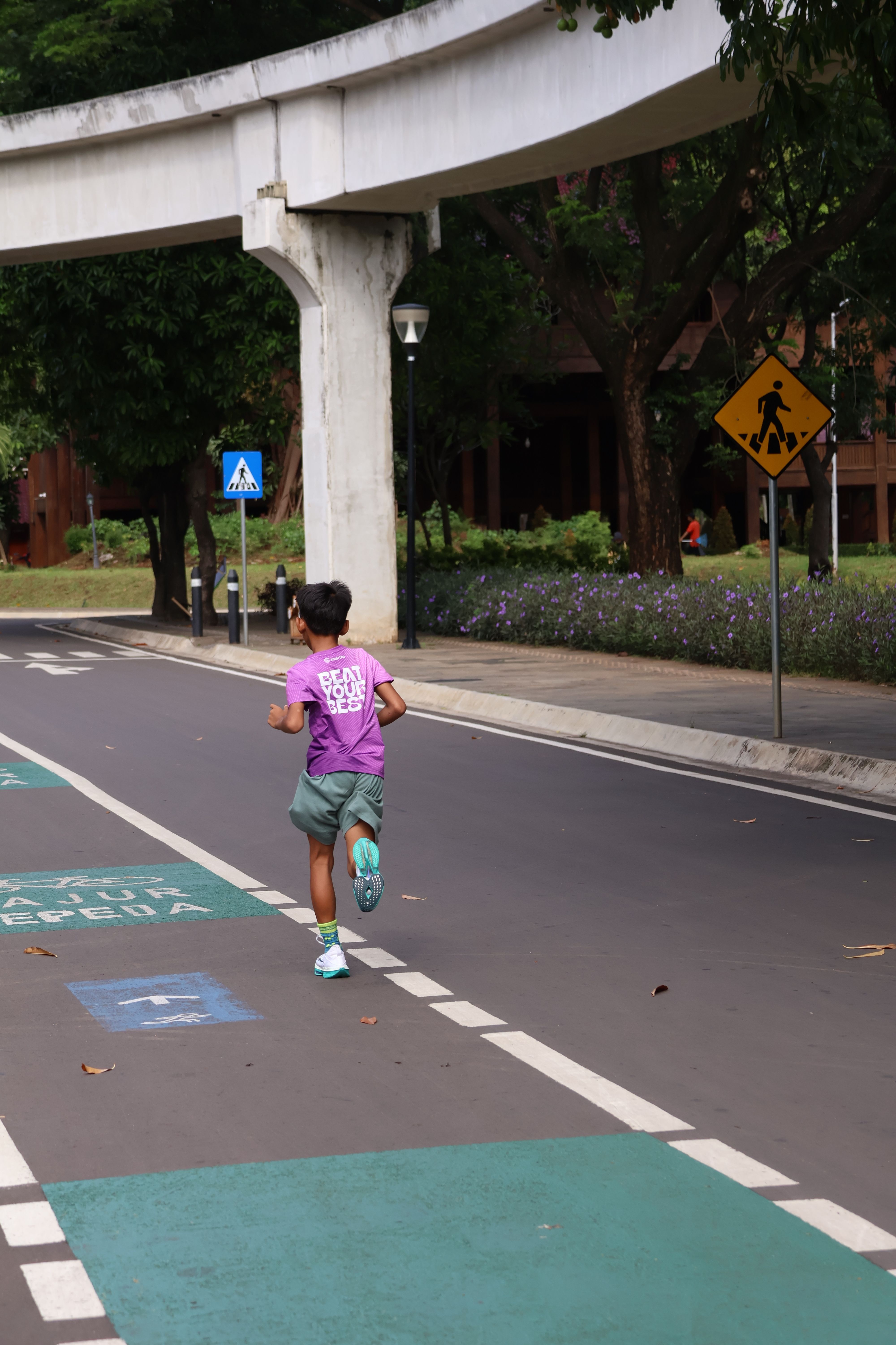 Child jogging on a dedicated path in Jakarta, Indonesia, emphasizing outdoor activities and fitness.
