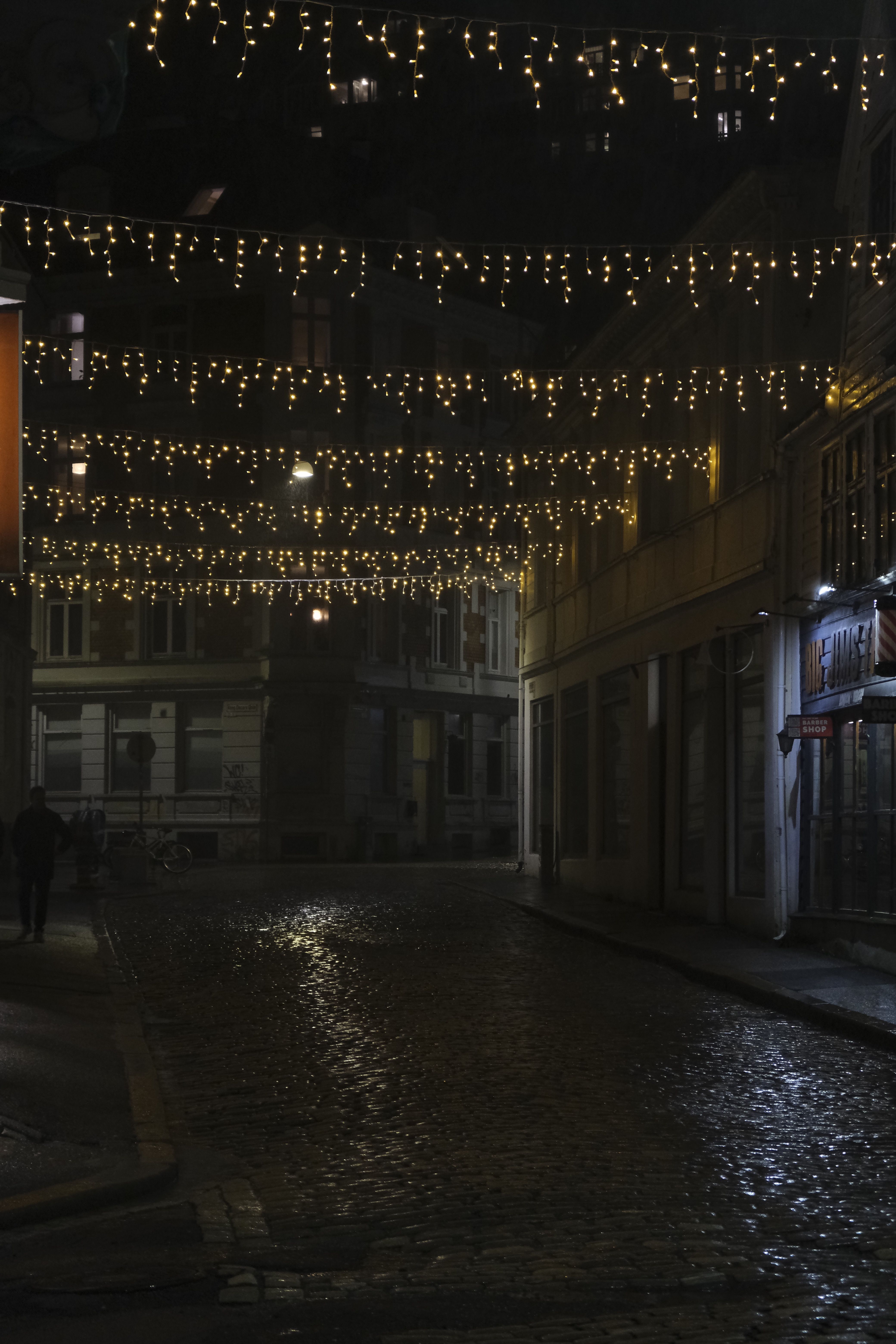 Charming Cobblestone Street with Festive Lights at Night · Free Stock Photo