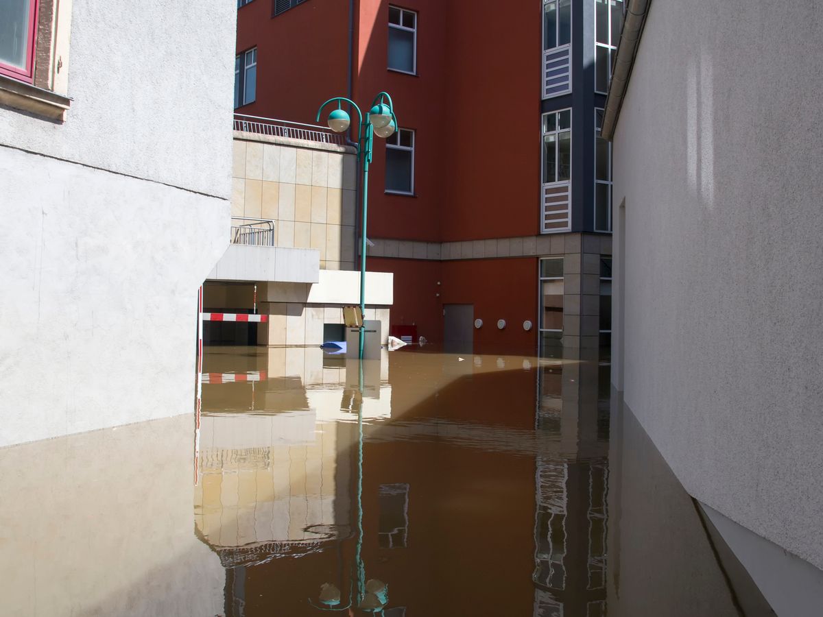 Urban flooding scene showing a waterlogged street and buildings after heavy rain